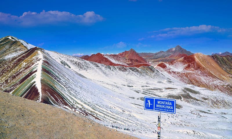 montanha do arco íris coberta por neve e uma placa escrita winikunka
