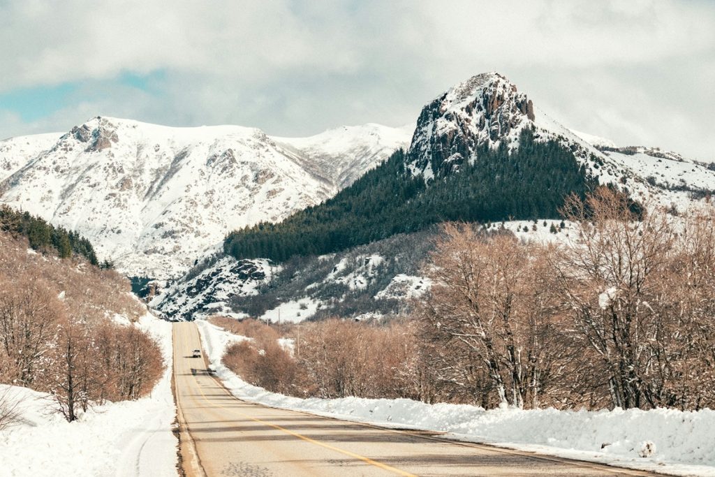 Estrada coberta de neve em San Martín de Los Andes com montanhas nevadas ao fundo durante o inverno na Patagônia argentina