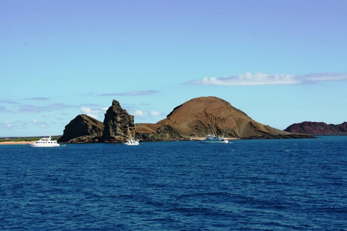 Vista panorâmica da Ilha Bartolomé com formações rochosas e iates no mar azul nas Ilhas Galápagos, Equador.