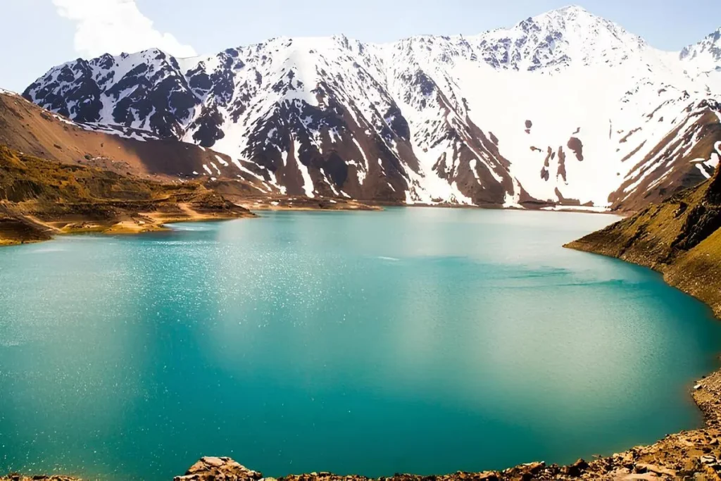 Bate volta na Lagoa Azul, Chile, com montanhas nevadas ao fundo e águas cristalinas.