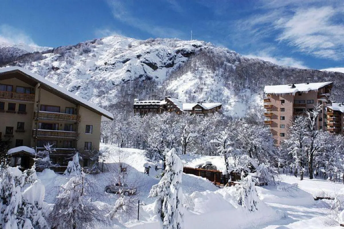 Nevados de Chillán, Chile: Hotéis de montanha cercados por neve em dia ensolarado.