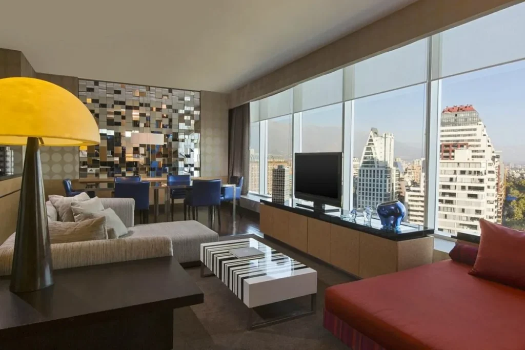 Suíte de luxo no W Santiago Hotel, com sala de estar e jantar em plano aberto e vista panorâmica da cidade.