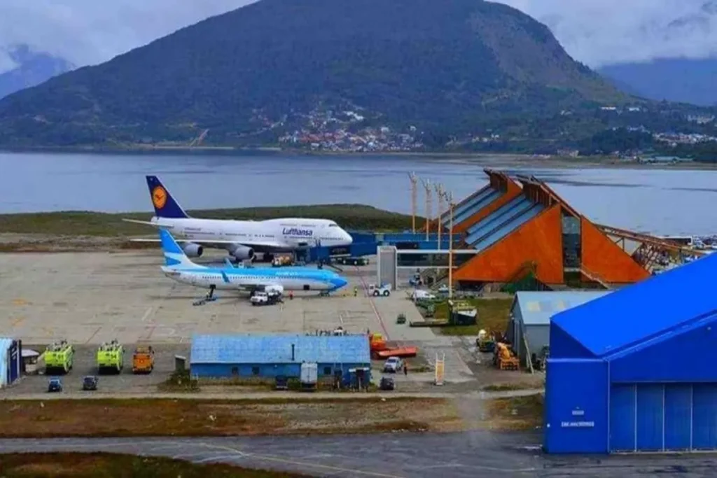 Aviões no Aeroporto Internacional de Ushuaia, com montanhas e o Canal de Beagle ao fundo.