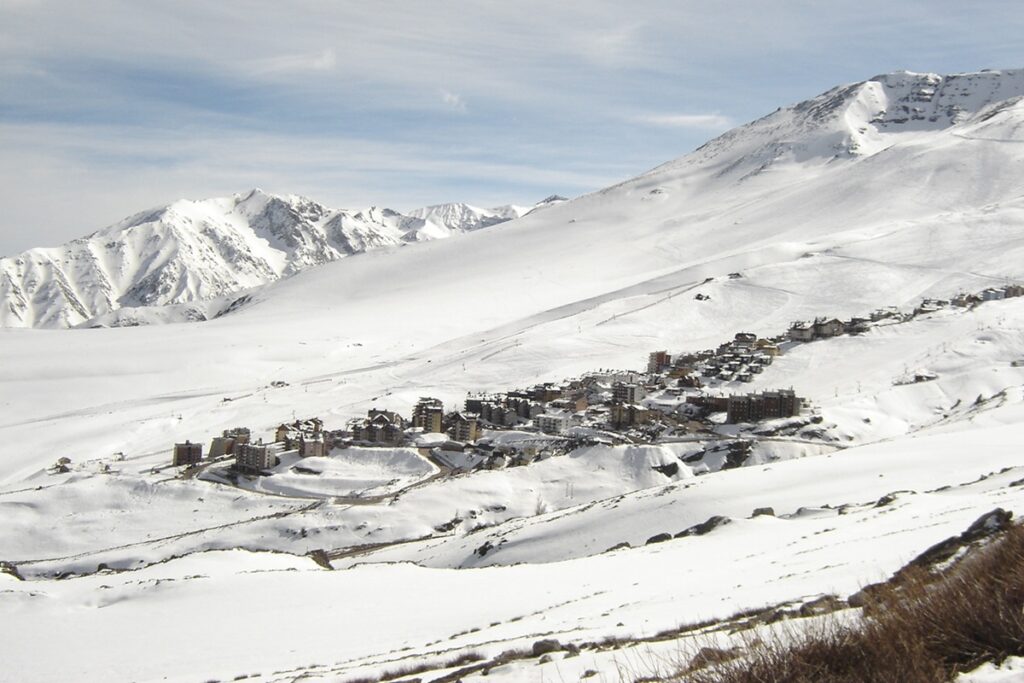 Vista ampla da estação de ski La Parva, no Chile, com vilarejo entre montanhas cobertas de neve.