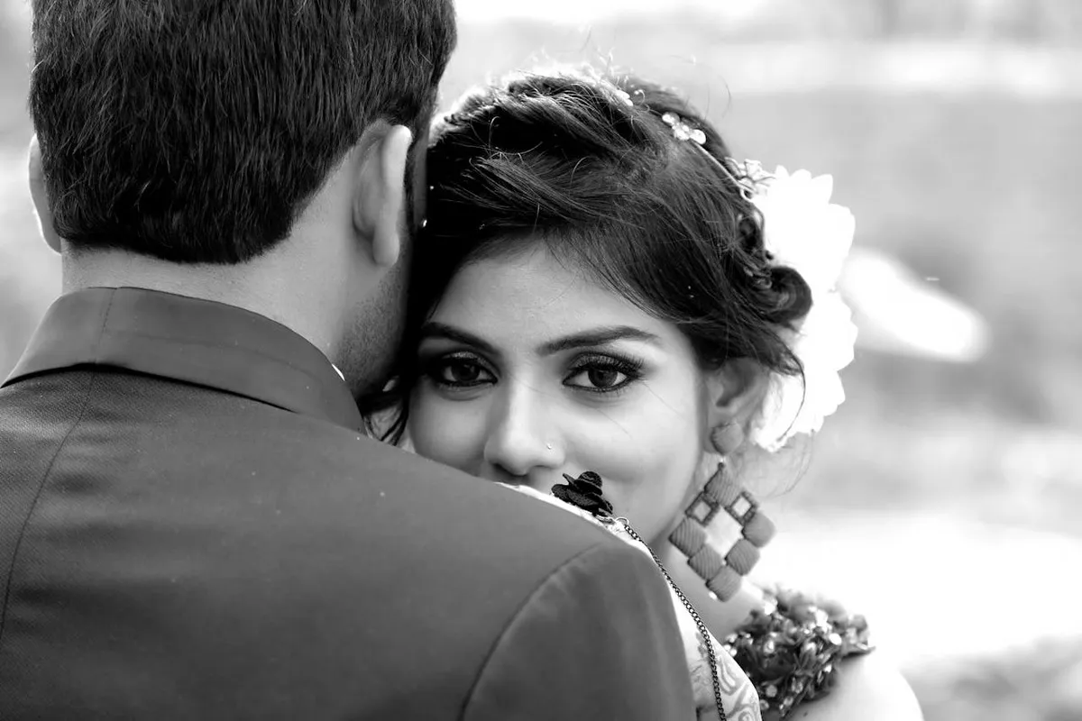 Retrato íntimo de um casal se abraçando após um pedido de casamento, em foto preto e branco.