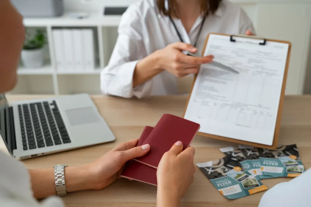 Quais documentos para entrada no Chile? Requisitos para brasileiros 2026 Pessoa segurando dois passaportes (vermelhos) enquanto um agente de viagens aponta para um formulário, revisando os documentos para entrada no Chile.