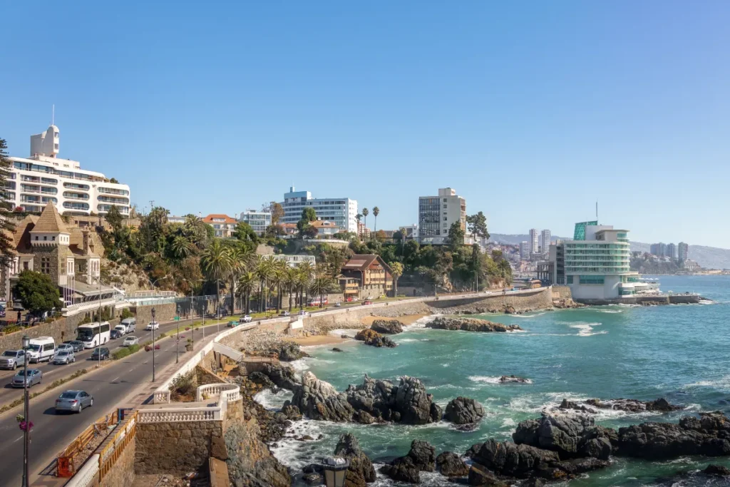 Trecho da costa de Mar del Plata com prédios, calçadão e formações rochosas banhadas pelo mar na Argentina.