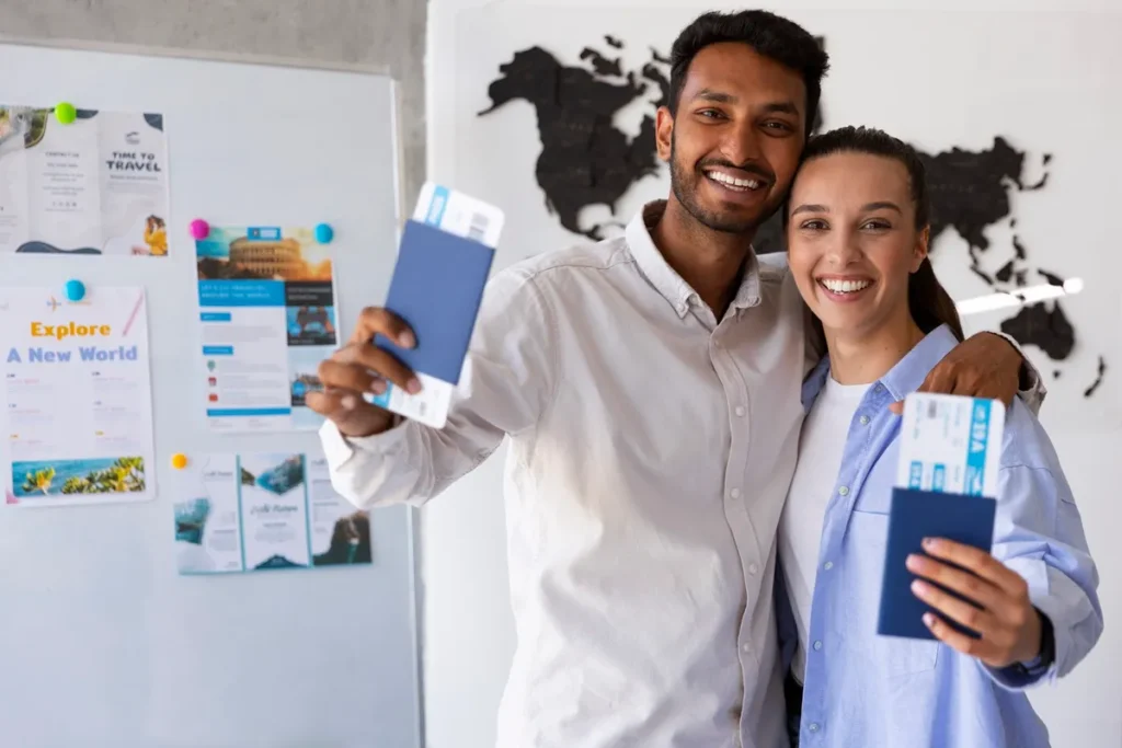 Seguro viagem internacional: é obrigatório para visitar a América do Sul? Casal sorridente segurando passagens aéreas e passaportes com seguro viagem internacional em agência de viagens, planejando viagem internacional
