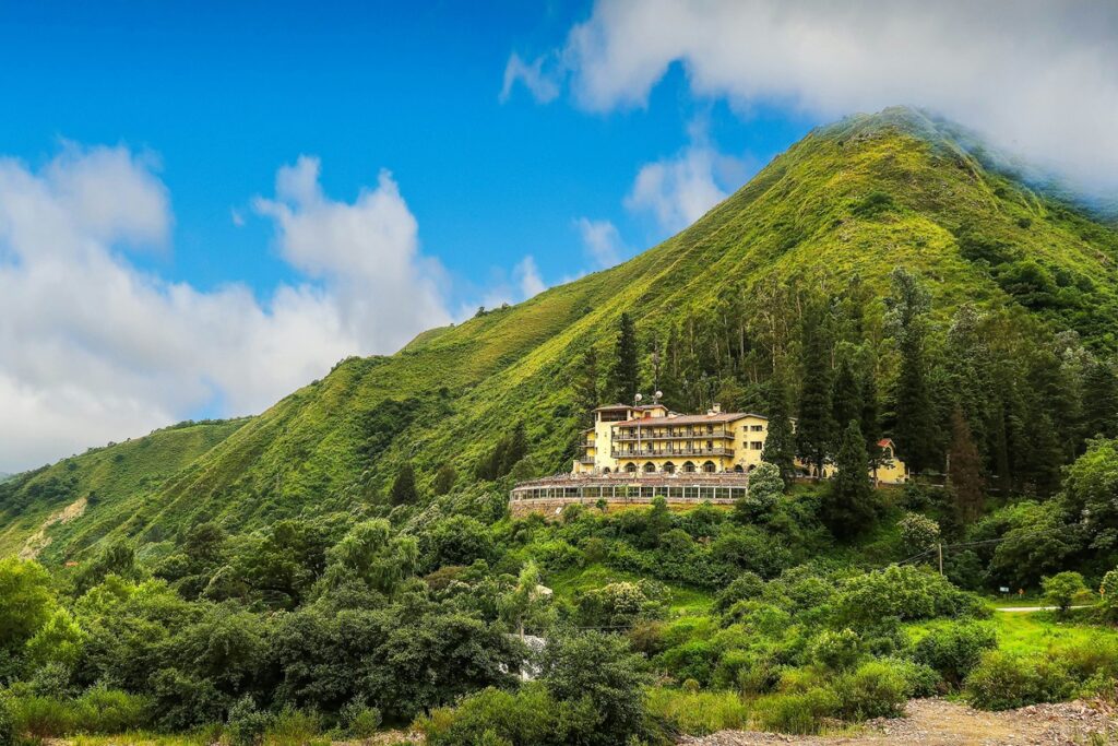 Hotel cercado por vegetação exuberante e montanhas verdes na província de Jujuy, no norte da Argentina.