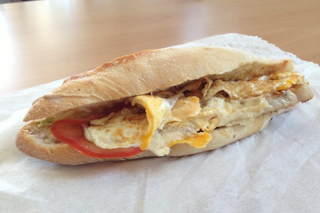 Chivito uruguaio servido no pão com carne, ovo frito, queijo derretido e tomate.