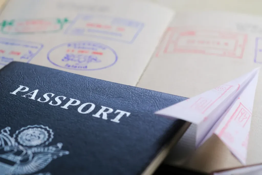 Documentos e cuidados no Circuito Andino. Passaporte azul parcialmente aberto sobre documentos de viagem com carimbos e páginas internas visíveis.