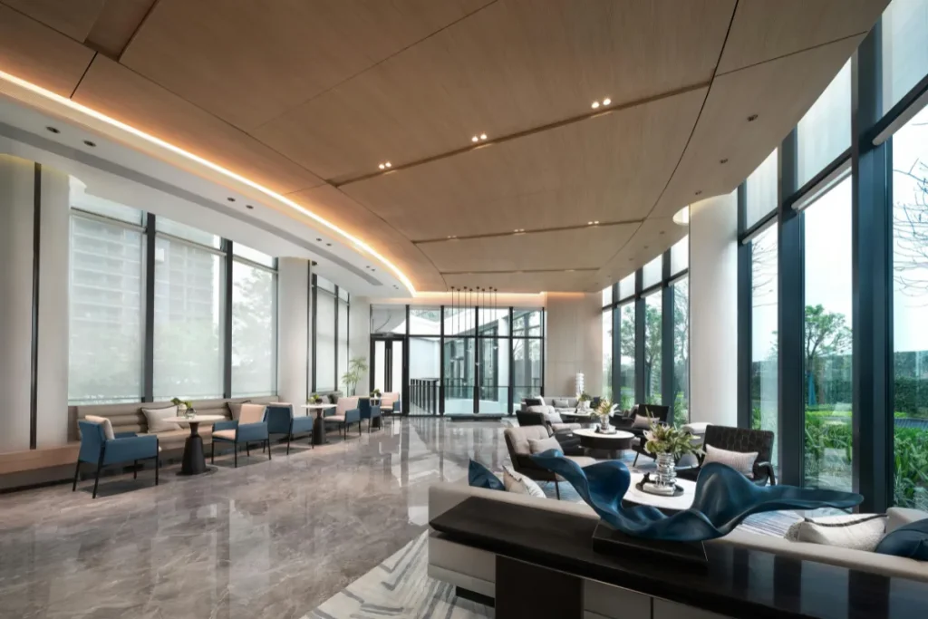 Salão de restaurante de hotel com mesas organizadas e grandes janelas de vidro usadas para servir café da manhã.