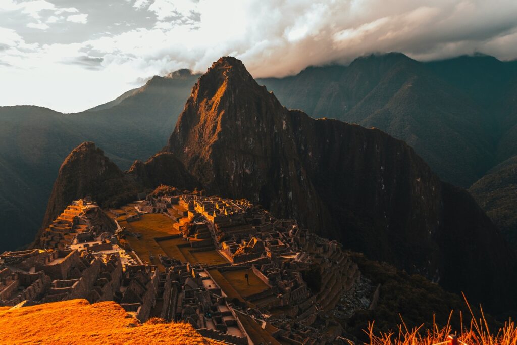 Vista aérea de Machu Picchu iluminada pela luz dourada do amanhecer.