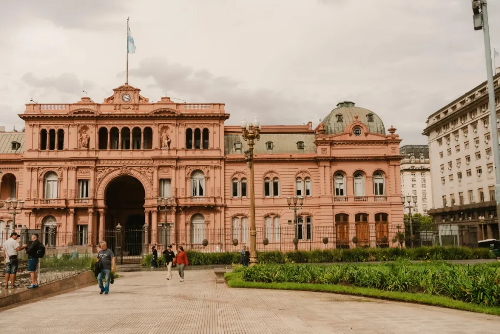 Fachada da Casa Rosada com arquitetura histórica e jardim na frente na Plaza de Mayo em Buenos Aires.