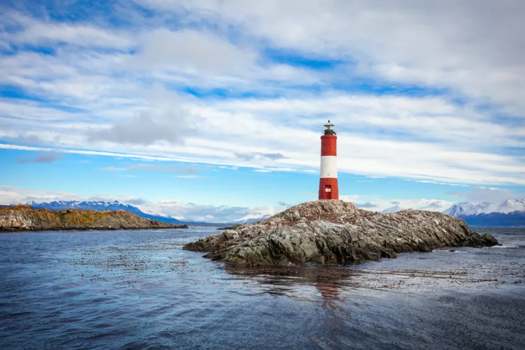 Farol vermelho e branco sobre ilha rochosa no Canal de Beagle em Ushuaia