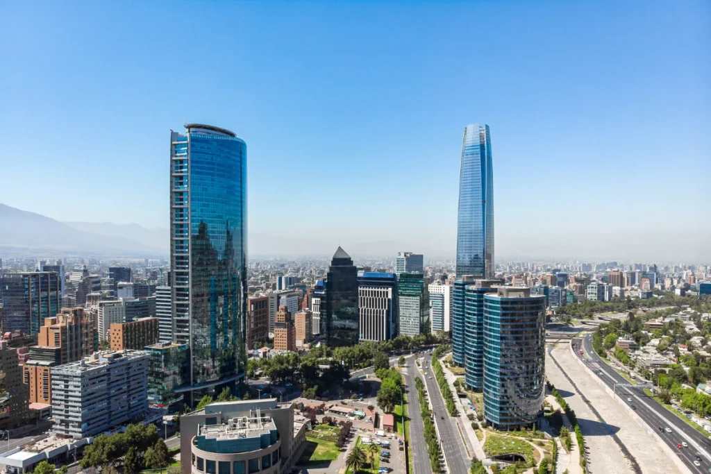 Vista aérea de Santiago com prédios modernos, avenida e rio atravessando a cidade