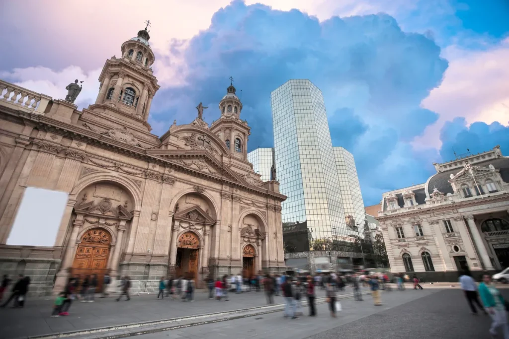 Catedral Metropolitana de Santiago com pessoas caminhando na praça e prédios ao redor