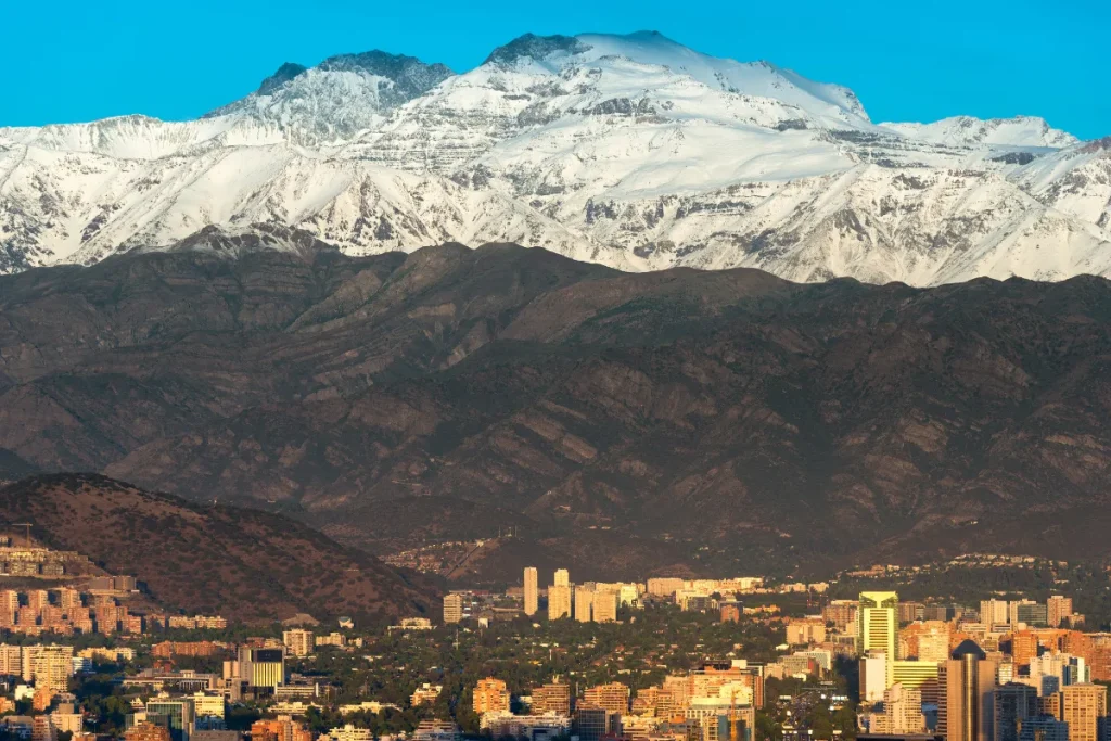 Vista da cidade de Santiago com prédios e montanhas nevadas ao fundo