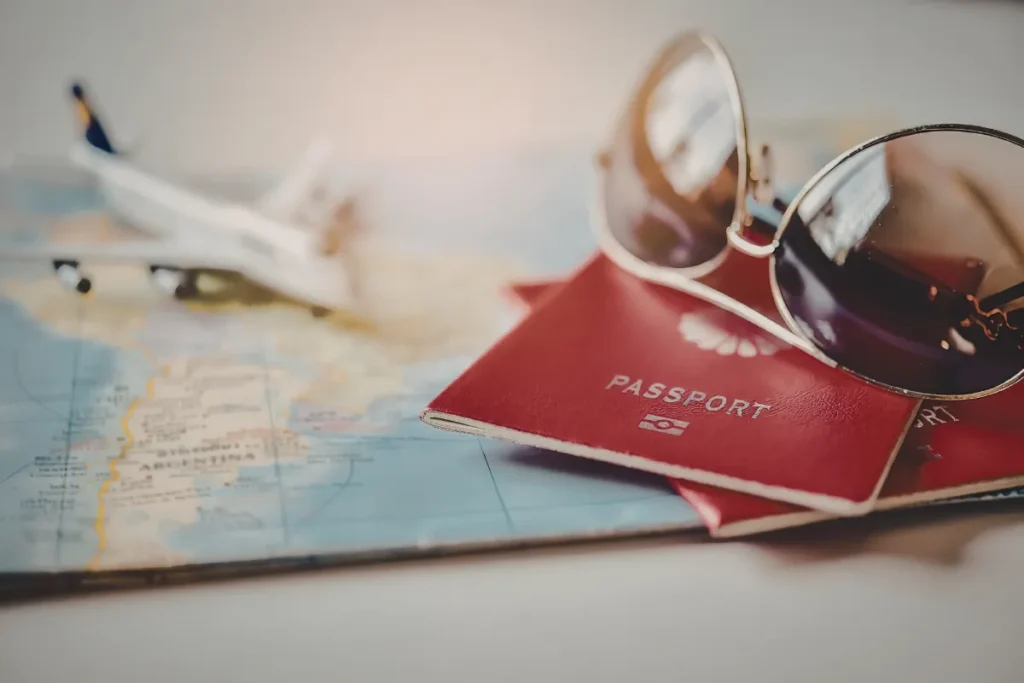 Passaporte com óculos sobre mapa e avião ao fundo, representando organização de documentos para viagem a Ushuaia
