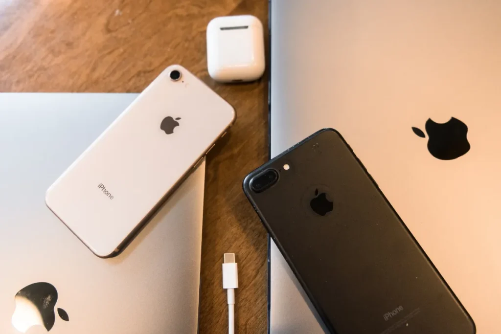 iPhones e notebooks Apple sobre mesa de madeira representando produtos premium vendidos no Chile.