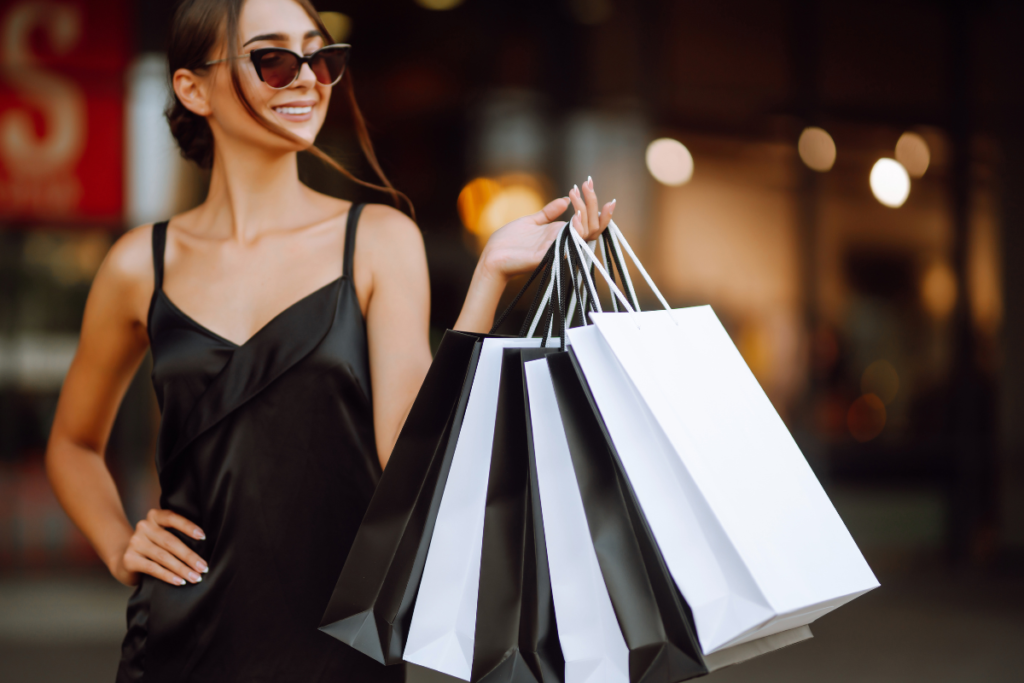 Mulher com sacolas elegantes em área comercial, representando compras de moda e acessórios no Chile.