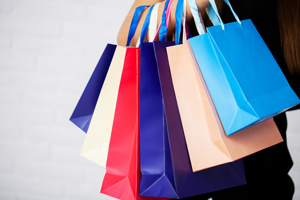 Pessoa carregando várias sacolas de compras após visitar lojas famosas no Chile durante viagem de compras.