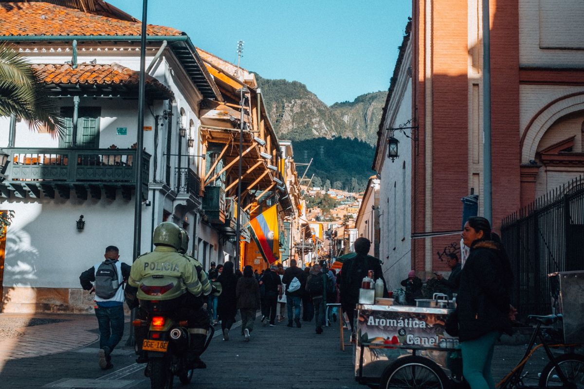 Rua movimentada em Bogotá com pedestres, comércio e edifícios urbanos