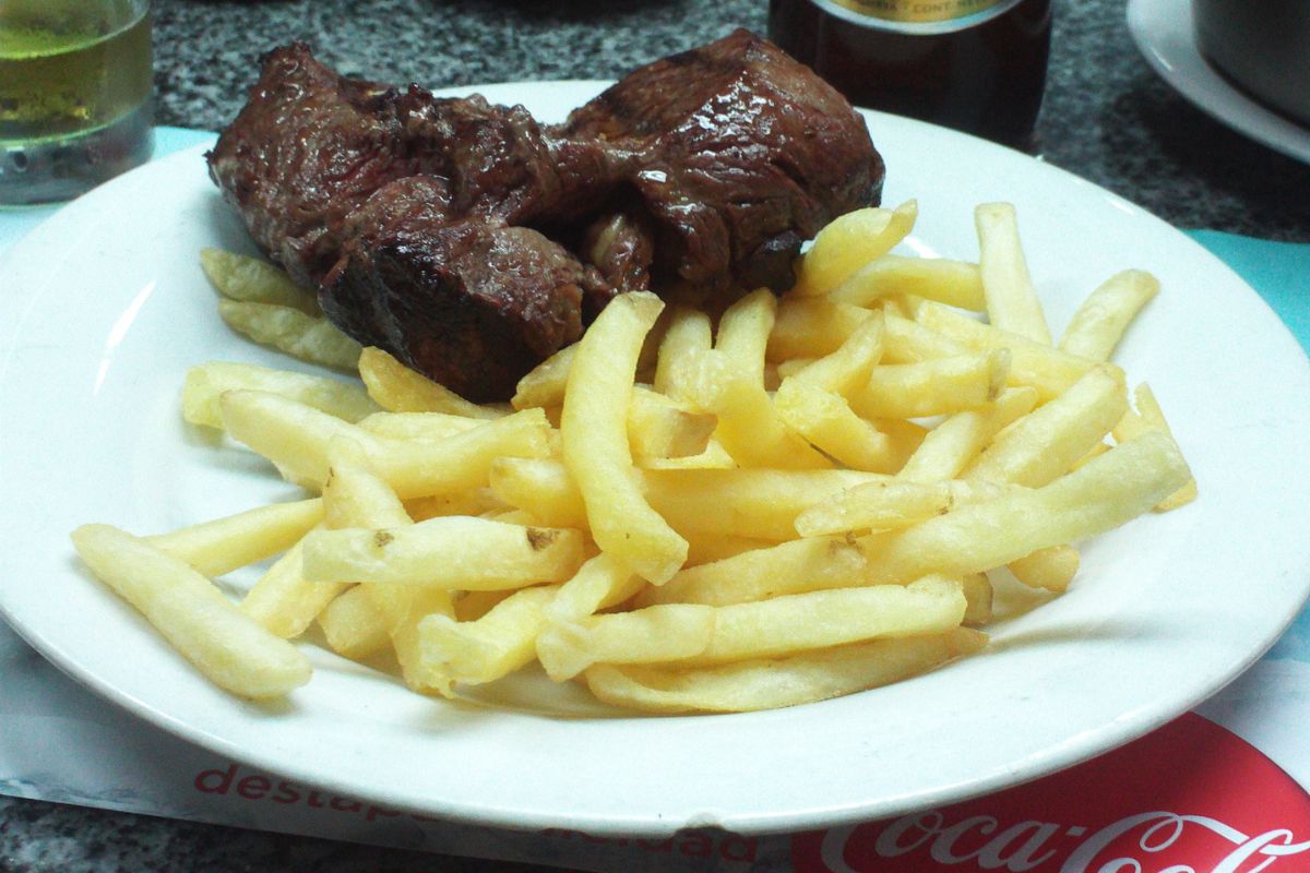 Prato de carne assada com batatas fritas servido no Mercado del Puerto, em Montevidéu