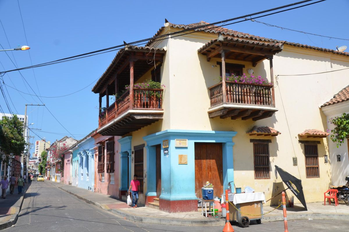 Cena de rua com arquitetura colonial e circulação de pessoas em Getsemaní, Cartagena