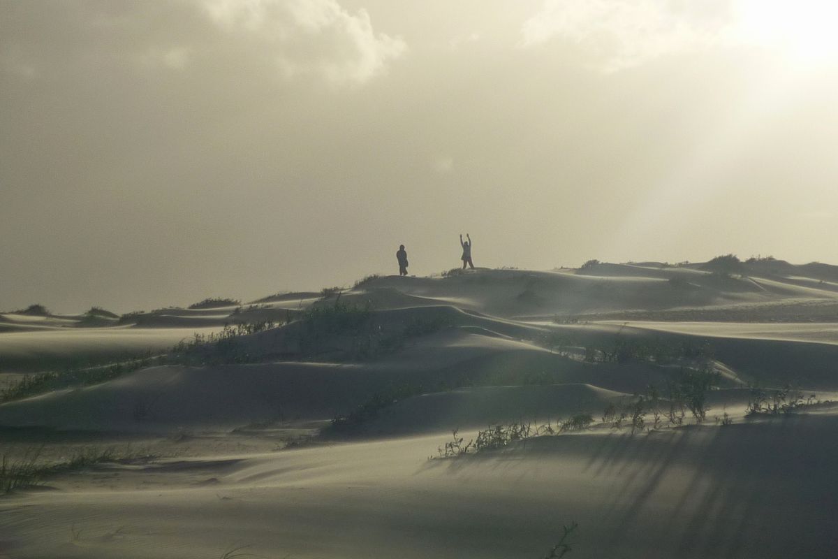 Dunas móveis de Cabo Polonio com duas pessoas caminhando sob céu nublado