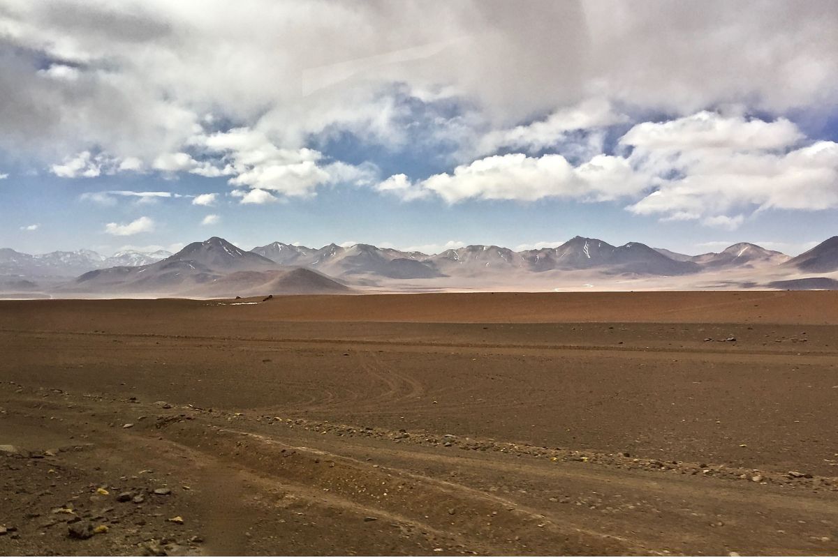 Estrada atravessa a paisagem árida e montanhosa do Altiplano andino entre Argentina e Chile