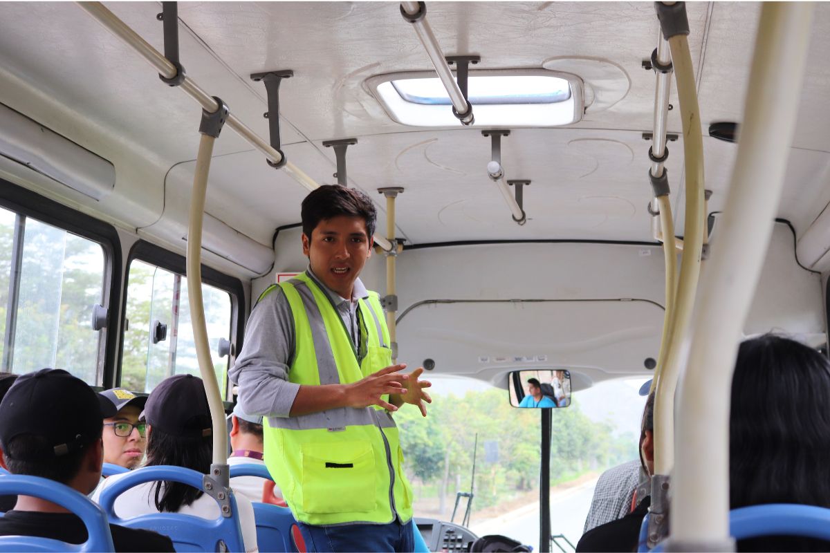Excursão: o que é, como funciona e o que avaliar antes de contratar Guia de turismo conversa com passageiros dentro de um ônibus em Lima, no Peru
