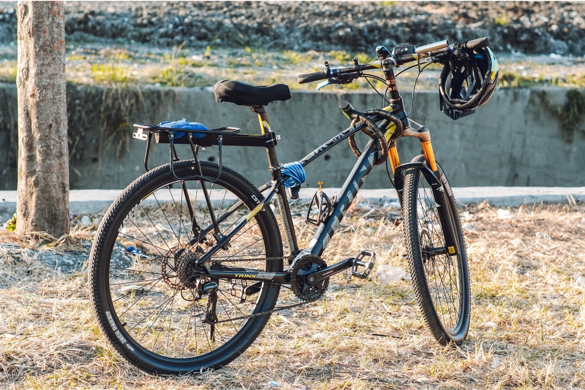 Mountain bike estacionada ao ar livre com capacete apoiado no guidão
