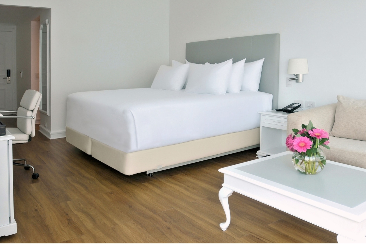 Quarto Superior do NH Collection Plaza Santiago com cama, poltrona e mesa de apoio