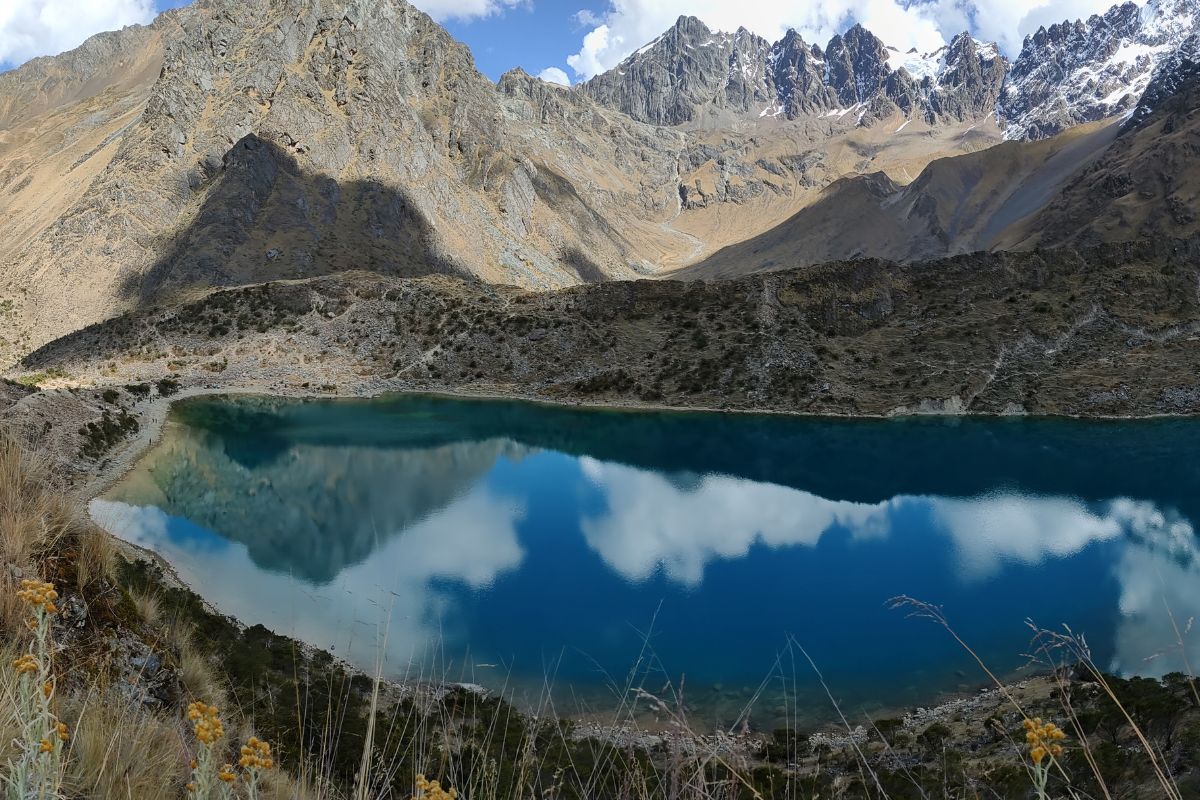 Panorama elevado da Laguna Humantay cercada por montanhas rochosas