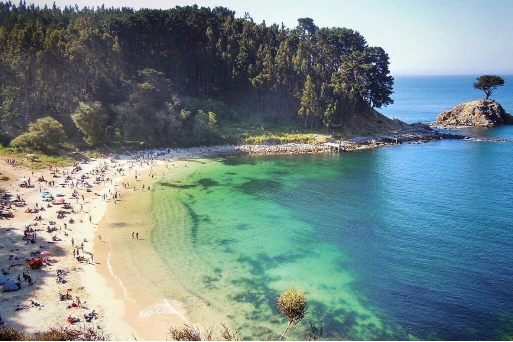 Playa Ramuntcho com faixa de areia, água azul-turquesa e vegetação na Península de Hualpén.