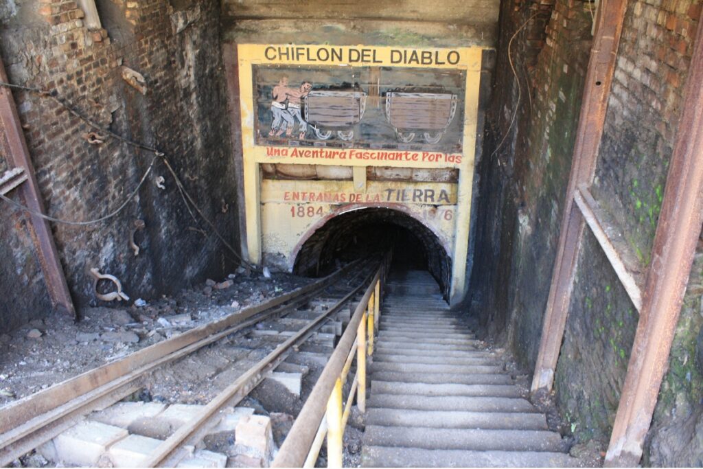 Entrada subterrânea da Mina Chiflón del Diablo com trilhos e escadaria em Lota, Chile.