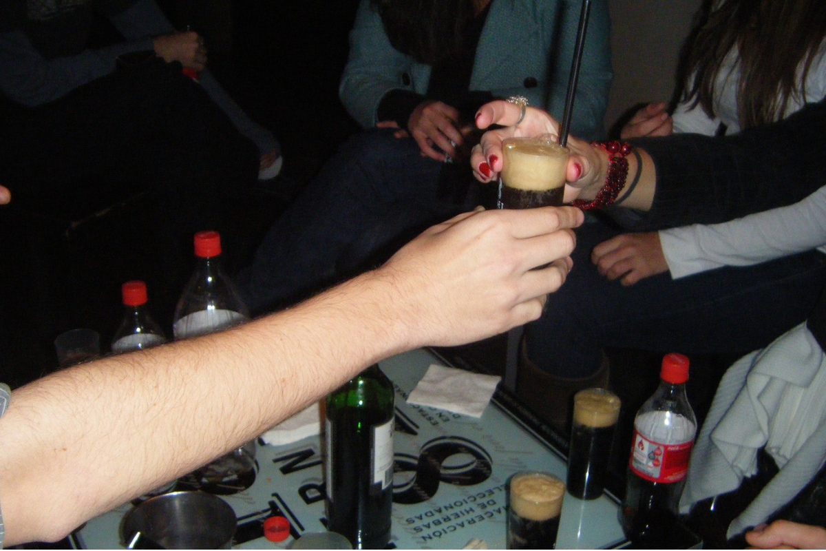 Garrafa de Fernet-Branca ao lado de uma taça com a bebida