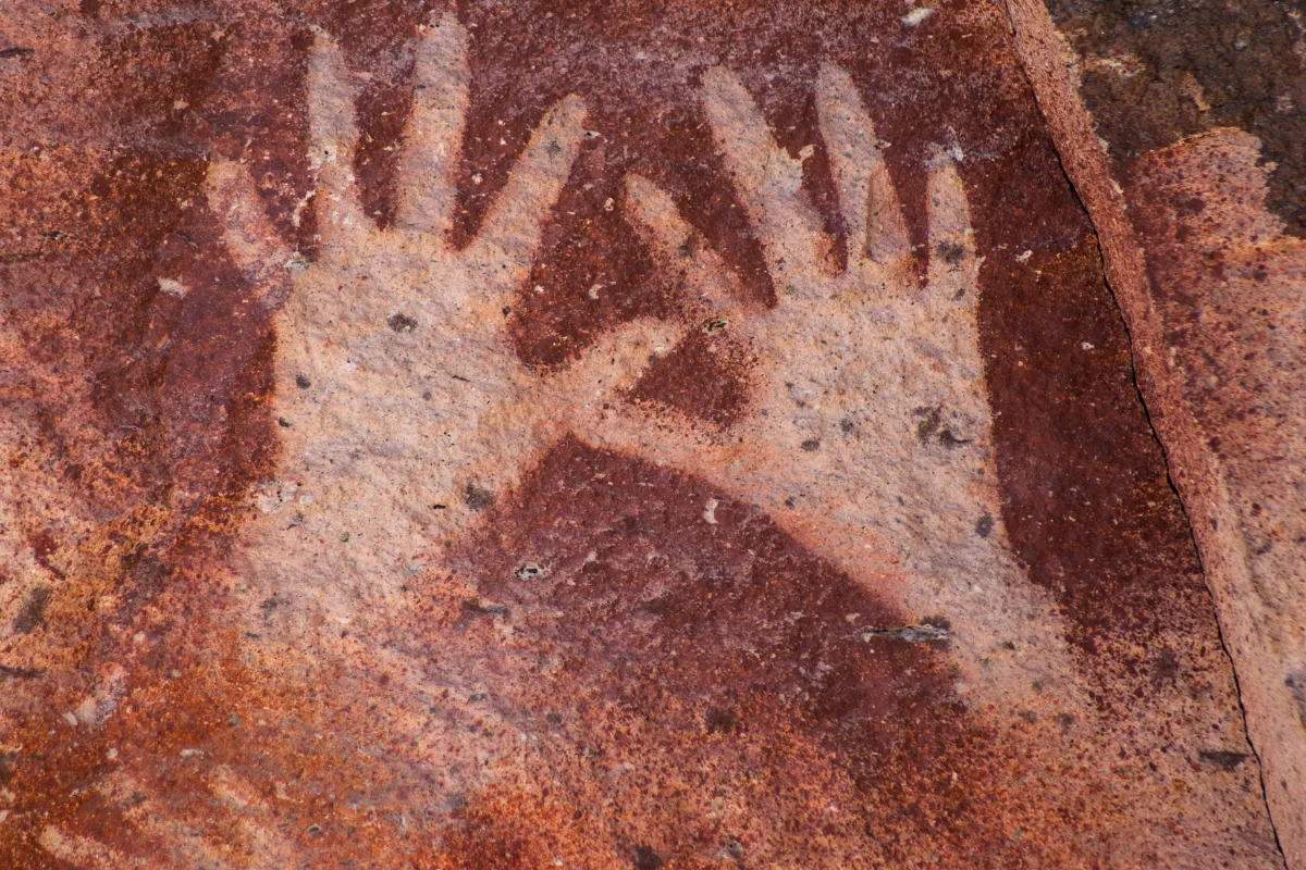 Detalhe de pinturas rupestres e mãos em negativo na Cueva de las Manos