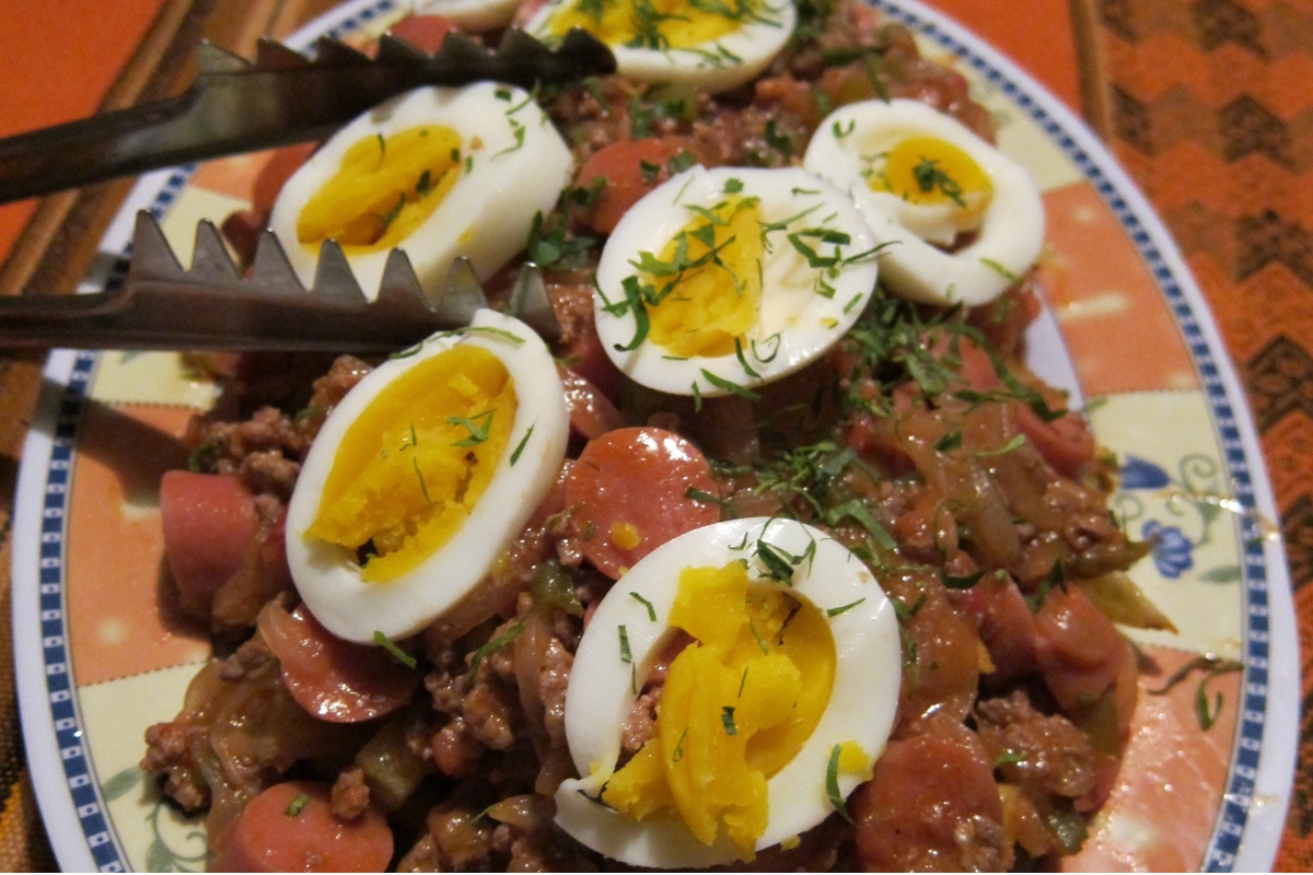 Porção de pique macho com carne, salsicha, batatas, ovos cozidos e molhos