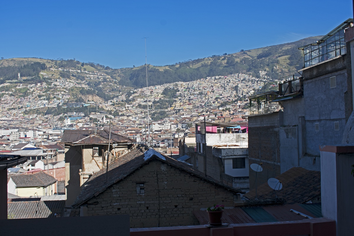 Vista panorâmica do Centro Histórico de Quito com construções coloniais e montanhas dos Andes ao fundo.