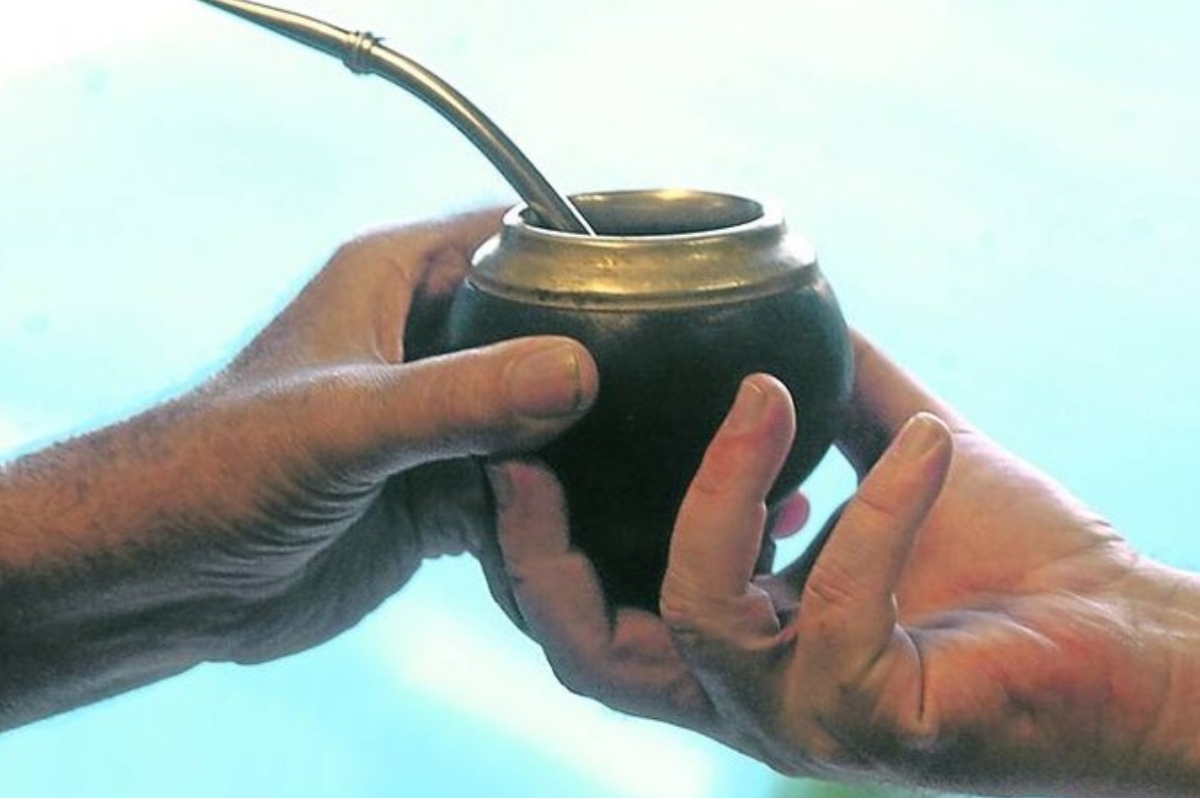 Duas pessoas compartilham uma cuia de mate durante uma roda