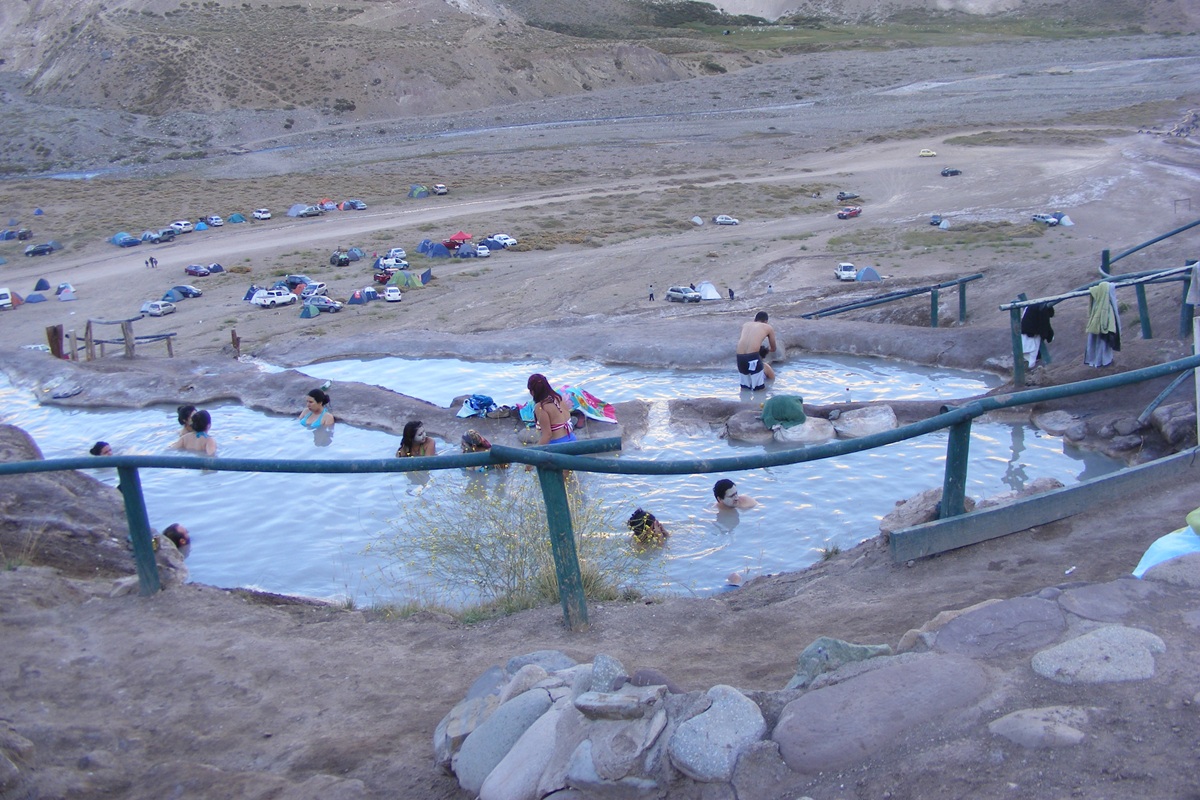 Piscinas termais em níveis nas Termas Valle de Colina, no Cajón del Maipo, cercadas por montanhas.