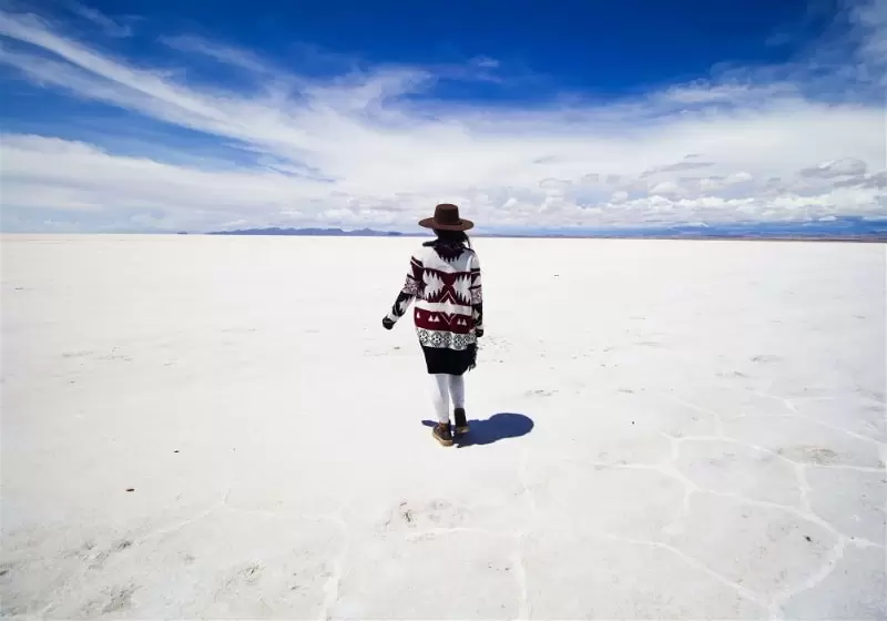 mulher caminhando com roupa etnica no salar de uyuni bolivia