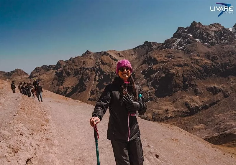 mulher com bastão na mão no trekking da montanha do arco-íris
