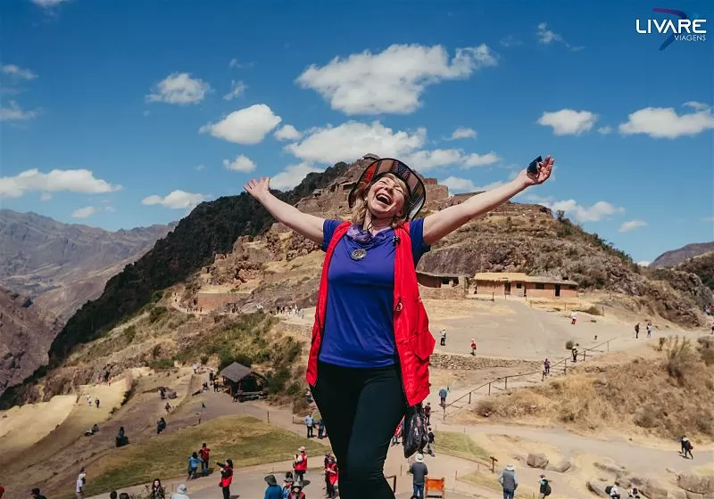 mulher de braços abertos feliz no valle sagrado dos incas