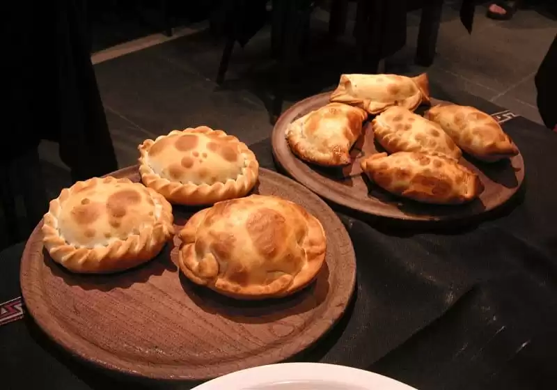 dois pratos de madeira com empanadas argentina